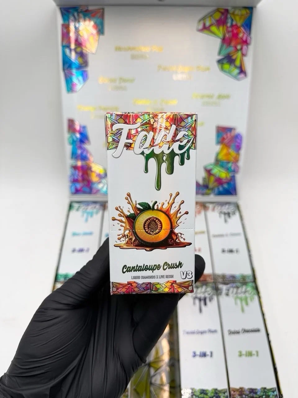 Fade 3-in-1 V3 Cantaloupe Crush box held up in front of an open display case